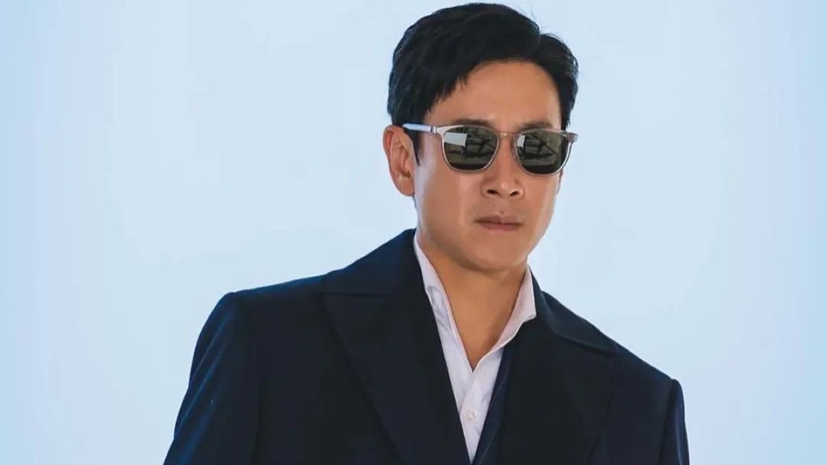Lee Sun Kyun shot wearing a blue jacket and black sunglass.